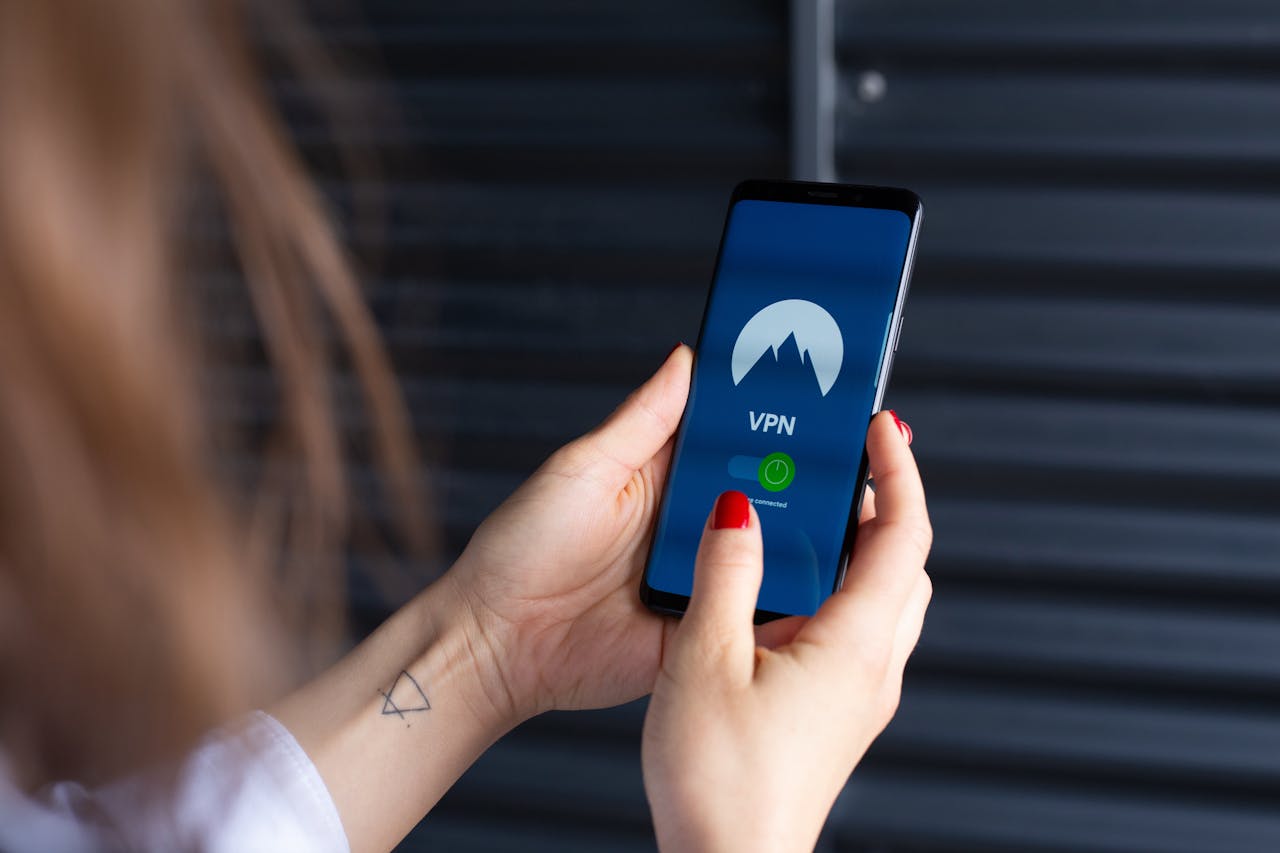 Close-up of a woman's hands using a VPN app on a smartphone, emphasizing digital security.